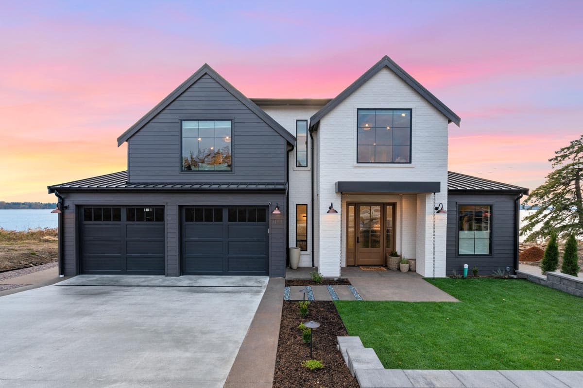 House plan exterior with two stories, Modern Farmhouse style. Features include a two-car garage, contrasting siding, and a gabled roofline.