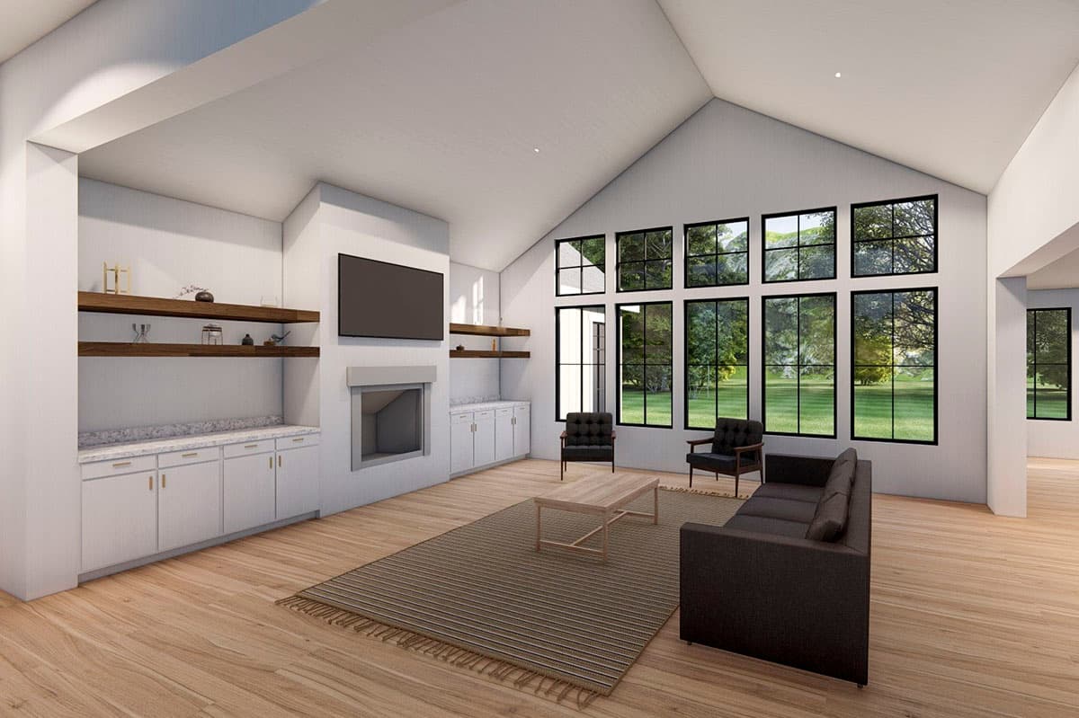 Living room with vaulted ceiling, fireplace, built-in cabinetry, and wall of windows overlooking greenery.