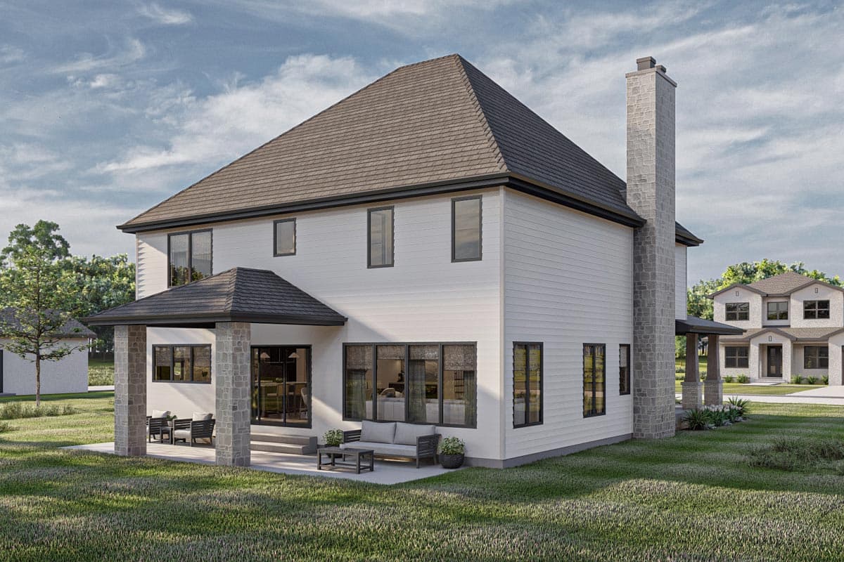 Two-story house plan exterior with gabled roof, stone chimney, covered patio with stone columns, and large windows.