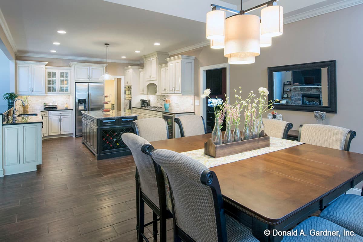 Open concept dining area and kitchen with dark wood flooring, white cabinetry, and a central island.
