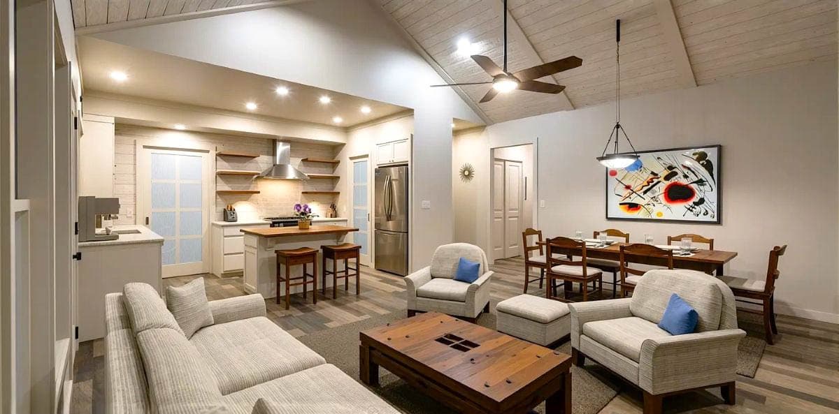 Open concept living area with vaulted ceiling, kitchen island, dining area, and living room seating.