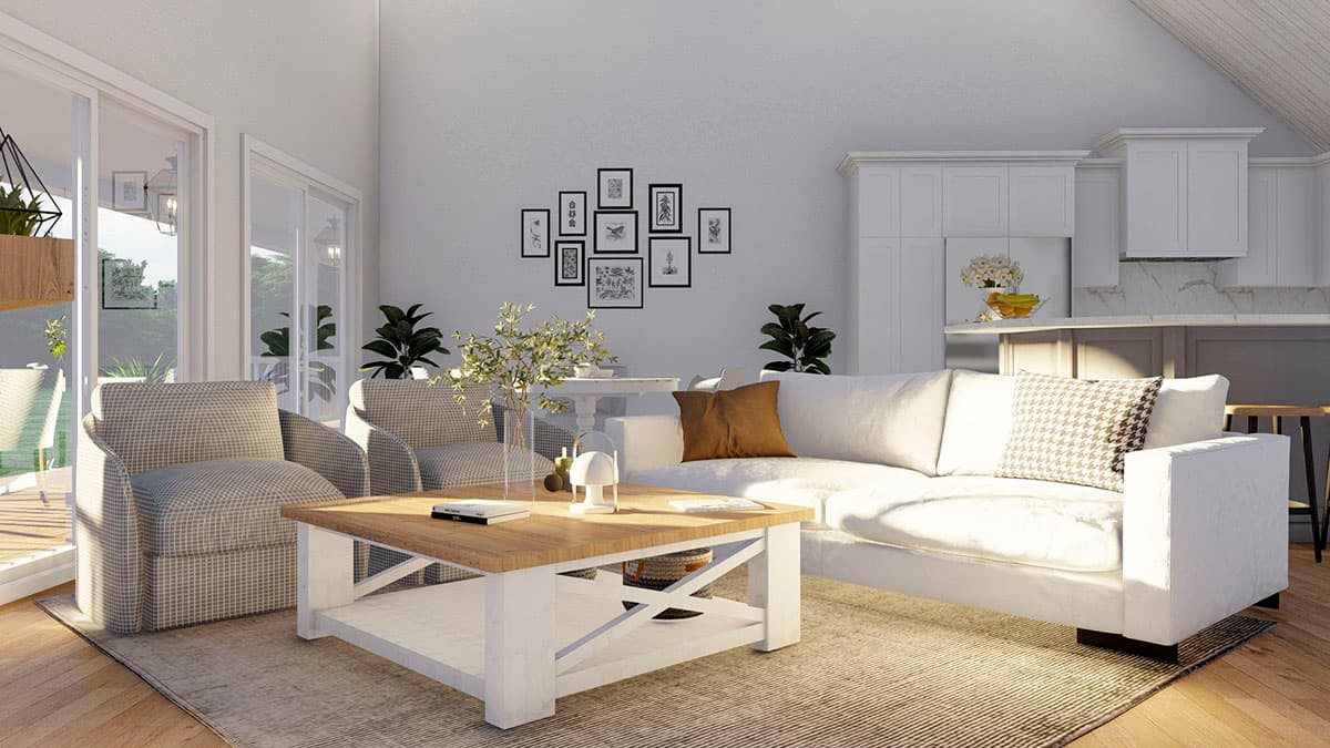 Open-concept living area with vaulted ceiling, white sofa, patterned armchairs, coffee table, and kitchen island.