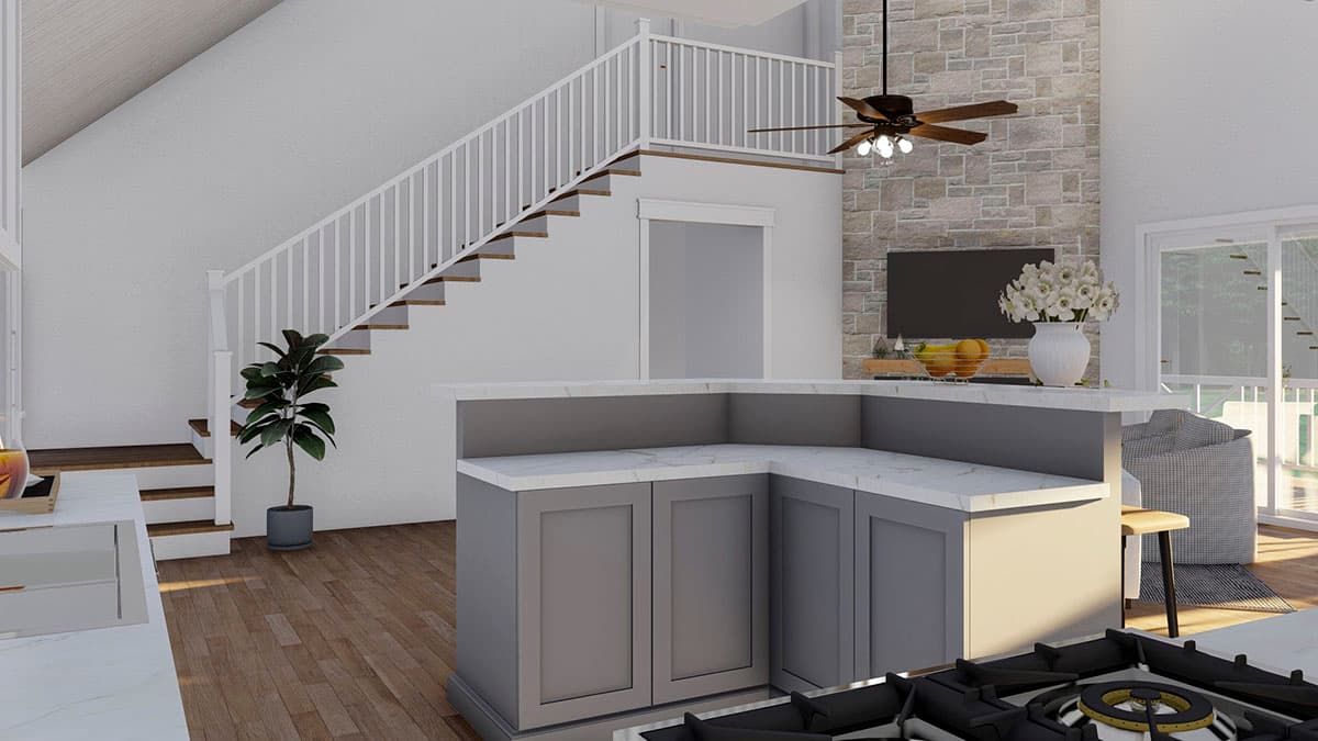 Open concept interior with kitchen island, stone fireplace, and staircase leading to a loft.