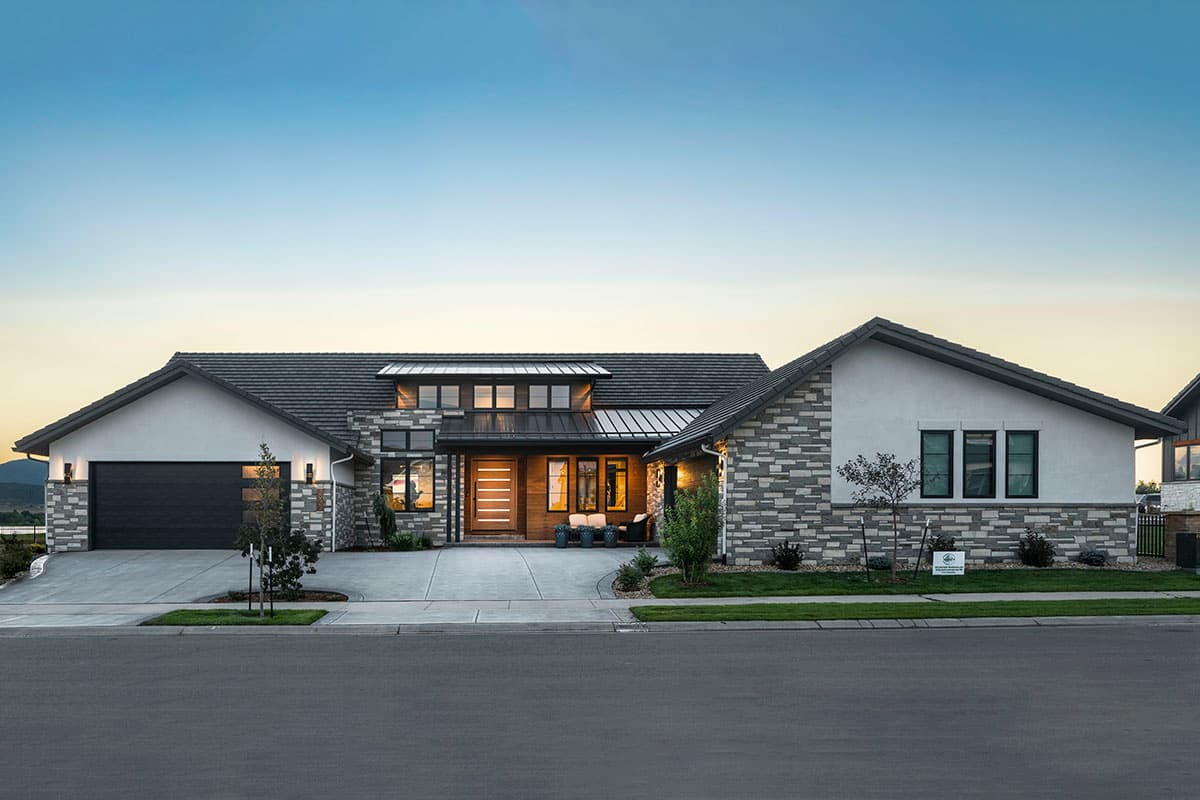 House plan exterior. Modern style, single story. Features include a mixed material facade, gabled rooflines, and a covered entry.
