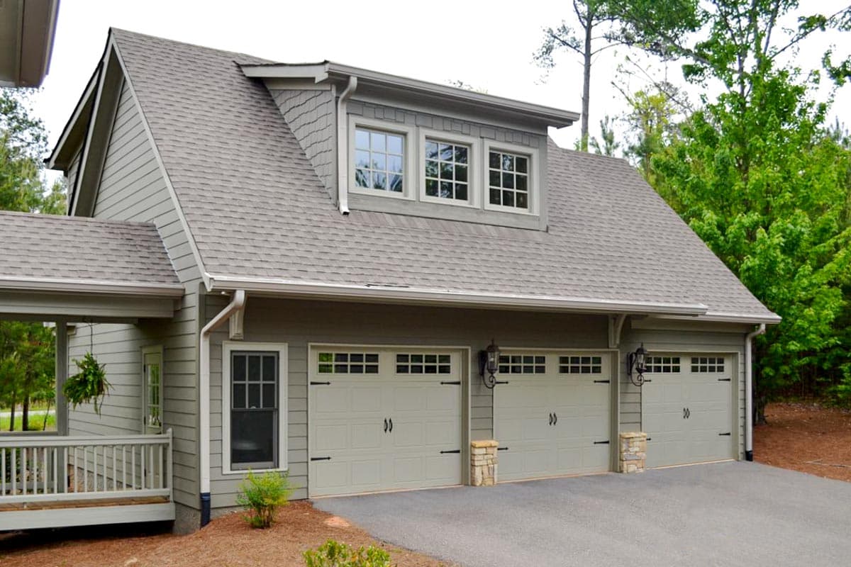 House plan exterior with Craftsman style, two stories, gabled roof, dormer windows, and three-car garage.