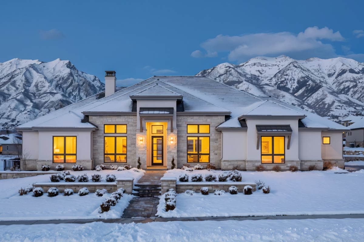 House plan exterior with modern style, large windows, stone accents, and a covered entry with double doors.