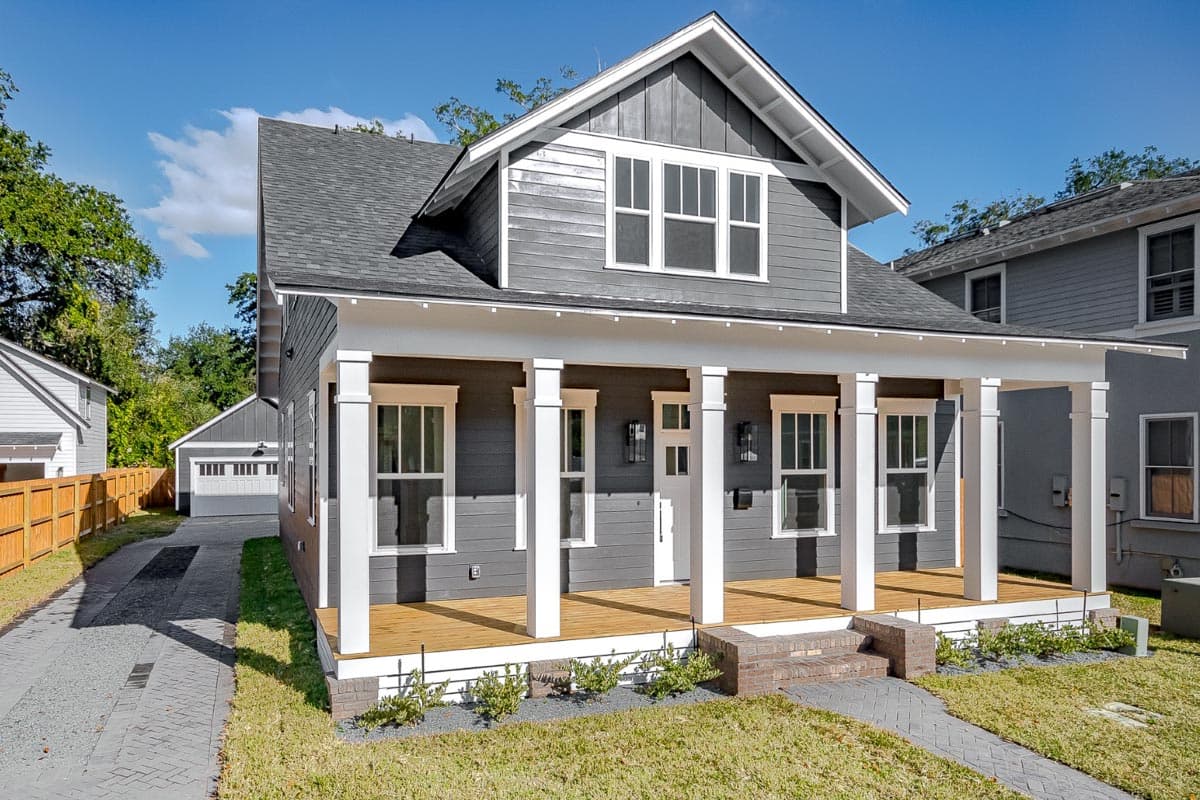 House plan exterior: Two-story Modern Farmhouse with a wide covered front porch, multiple gables, and a detached garage.