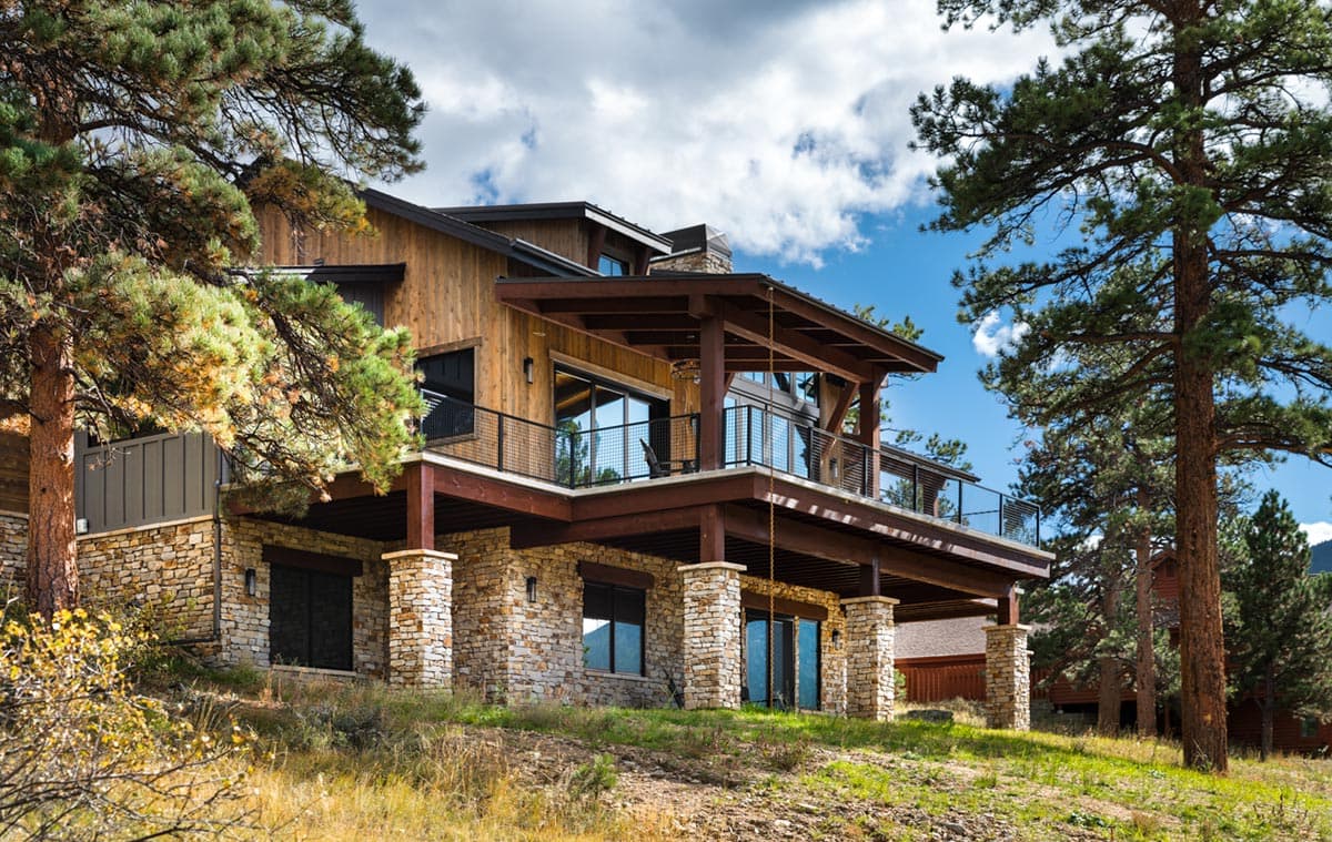 Modern Mountain house plan exterior with wood siding, stone foundation, and multi-level decks.