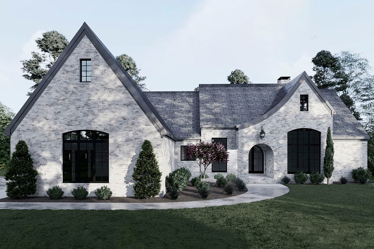 House plan exterior: European style with white brick, prominent gables, arched windows, and a curved entrance.