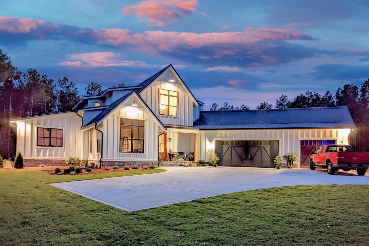 House plan exterior. Modern farmhouse style with vertical siding, two stories, gable roof, covered porch, and attached garage with barn-style doors.