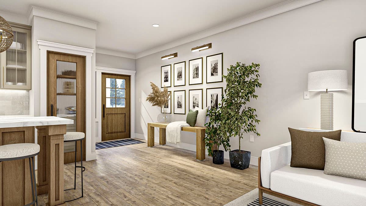 Interior view showing a kitchen island with stools, a wood-paneled door, and a gallery wall.