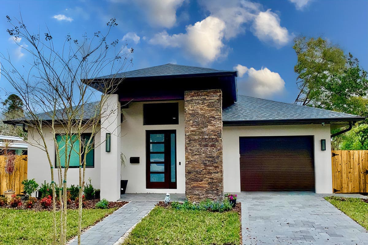 House plan exterior. Modern style, single story home with flat roof, stone facade pillar, and attached garage with dark brown door.