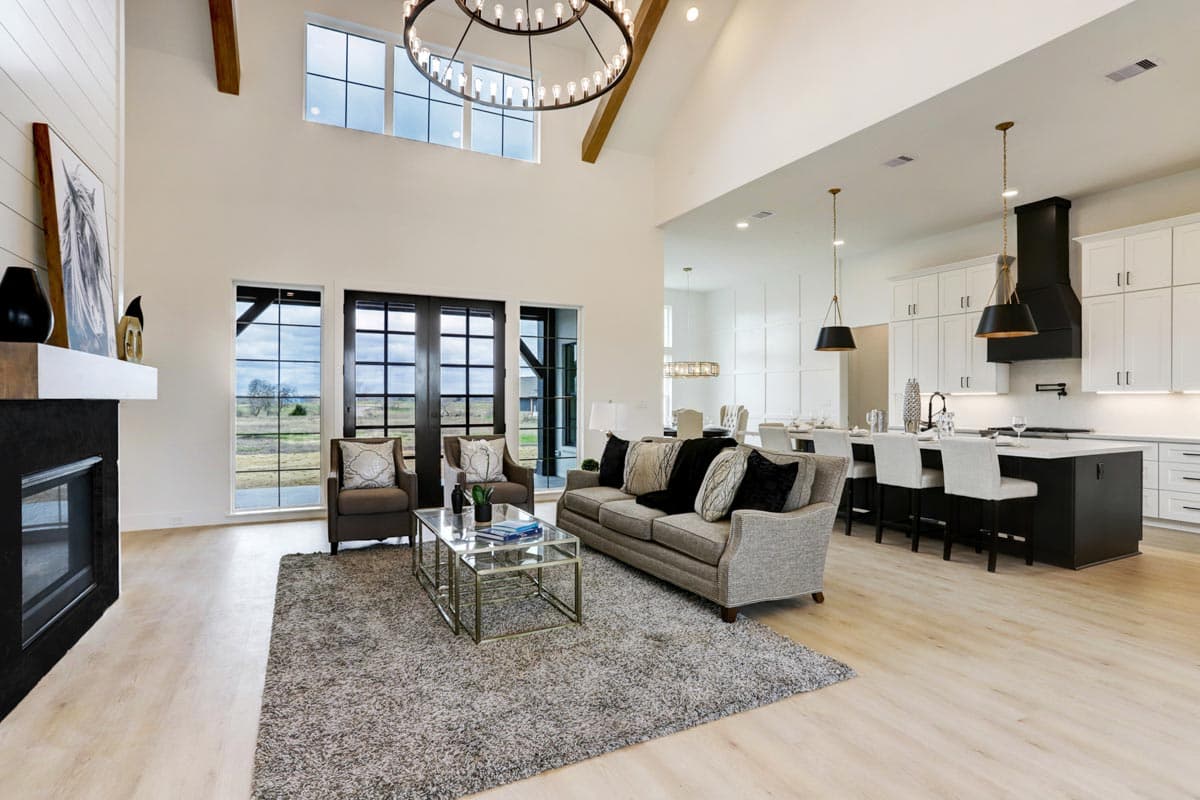 Open-concept living space with vaulted ceilings, fireplace, and modern kitchen with island seating.