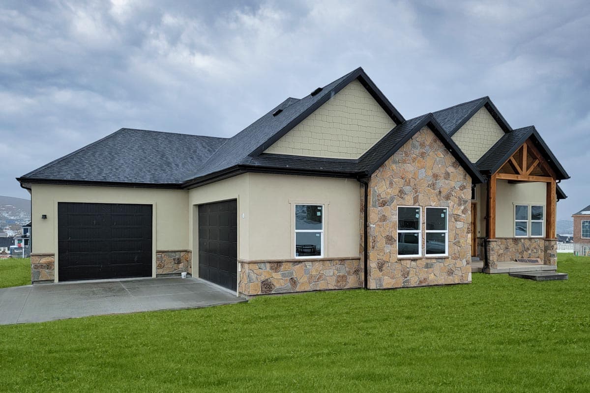 Exterior house plan with stone and stucco facade, gabled rooflines, and a two-car garage.