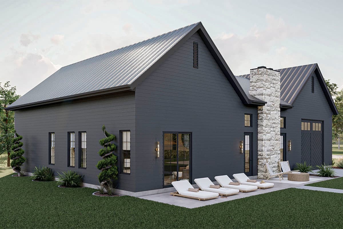 Modern farmhouse style house plan exterior with dark siding, metal roof, stone chimney, and detached garage.