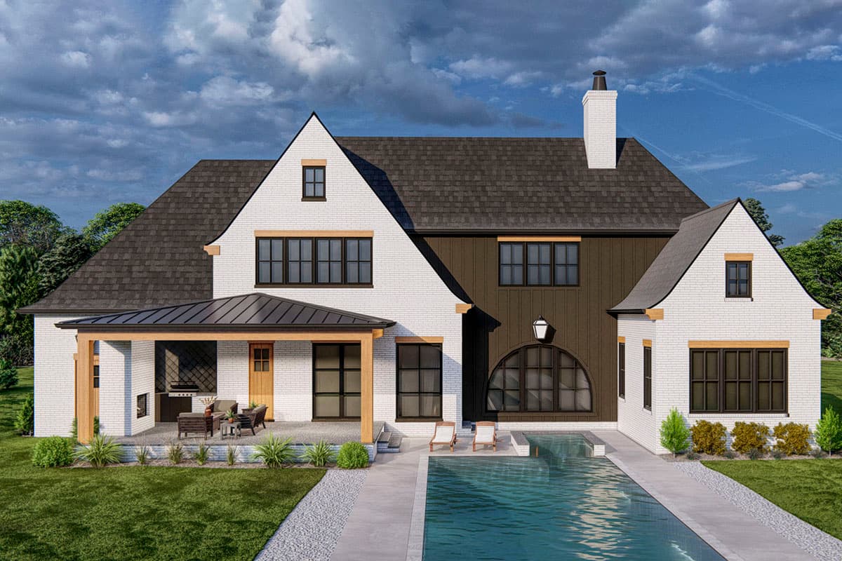 House plan exterior: White brick, multi-story home with gables, dark metal roof, covered patio with outdoor kitchen, and arched window.