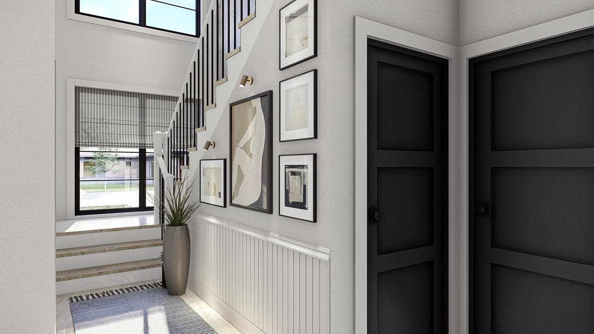Interior view of a staircase with wainscoting, art, and black doors. Features include floor-to-ceiling windows and a runner.