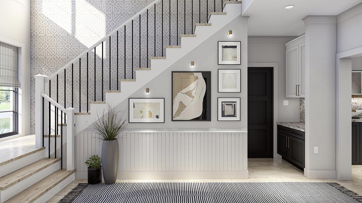 Interior view of a staircase with geometric wallpaper, black balusters, wainscoting, and modern art.