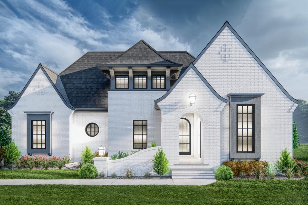 House plan exterior with brick facade, arched entry, multiple gables, and dark roof. Features include round and rectangular windows.