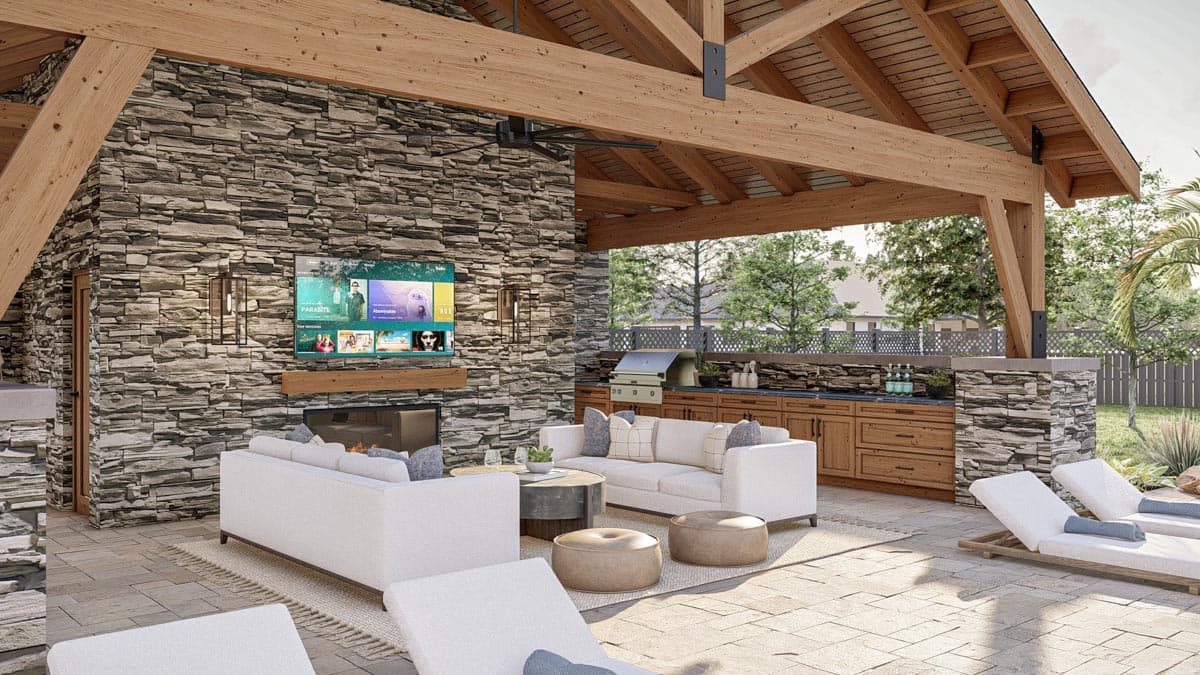 An outdoor patio with a stone fireplace, TV, and comfortable seating under a wooden pergola, plus a grill and lounge chairs.