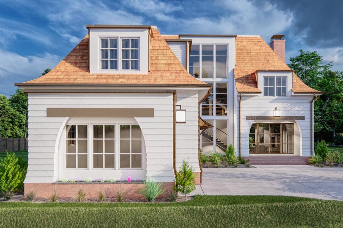 House plan exterior featuring a steeply pitched roof with dormers, shingle siding, and arched window details.