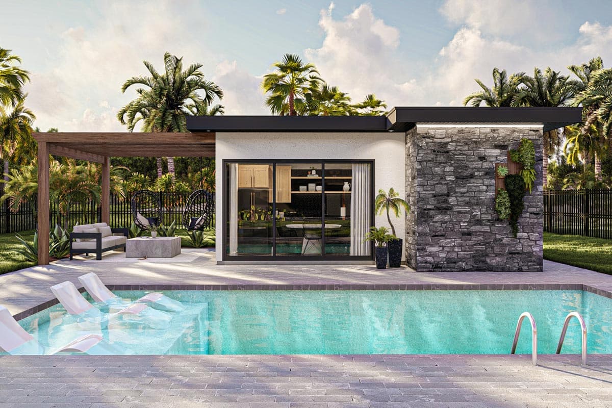 A modern luxury home with a pool and a cozy patio. Palm trees surround the outdoor space, and the house has a stone accent wall.