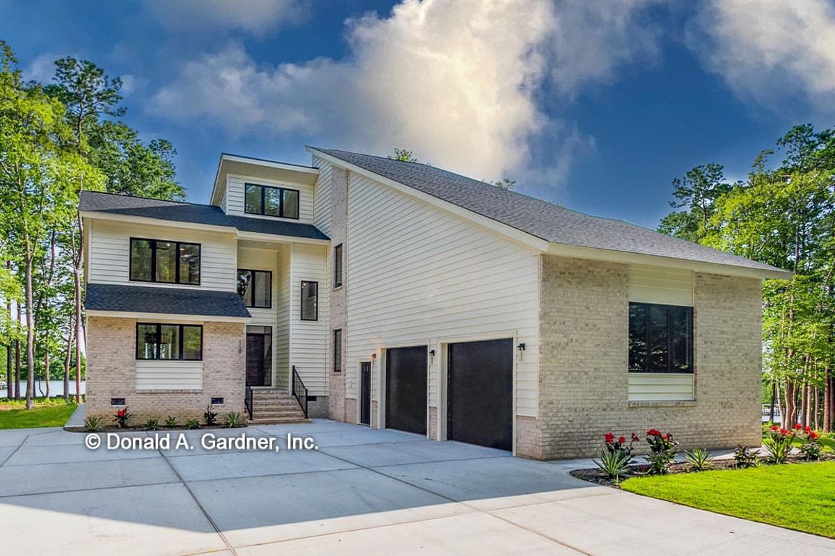House plan exterior. Two-story modern style with brick and siding, a multi-gabled roofline, and attached garage. Black trim and doors.