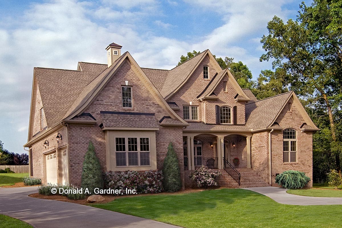 House plan exterior of a two-story brick home. Features include multiple gables, a covered front porch, and a side-entry garage.
