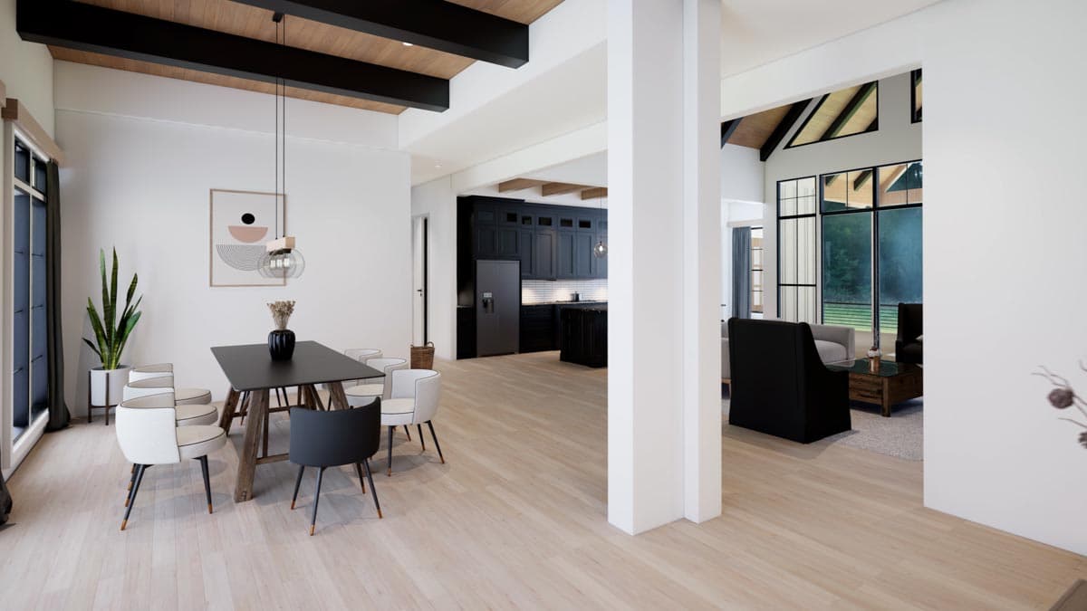 Modern open-plan living and dining space. Features a dining table, chairs, adjacent kitchen, and a separate lounge area visible through a doorway.