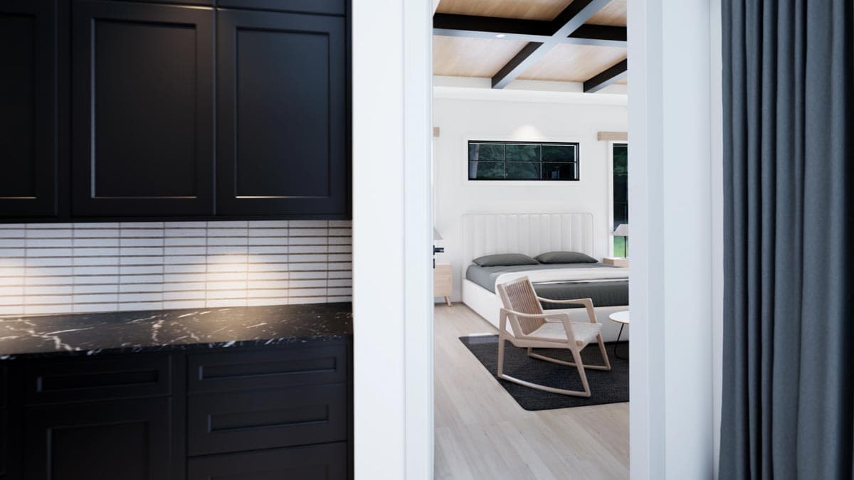 View through a doorway into a modern bedroom, showcasing a bed, chair, and dark gray curtains. Black kitchen cabinets are in the foreground.