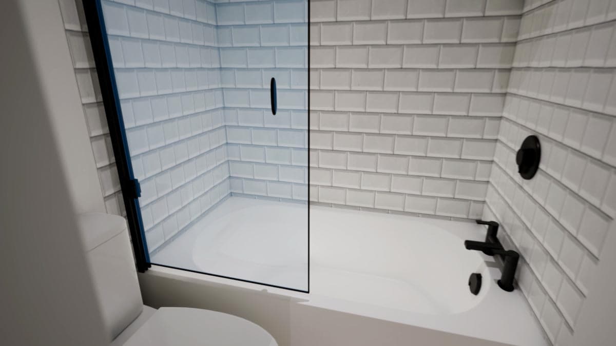 A modern white bathroom with a glass shower door. Black fixtures contrast the white tile walls and bathtub. A toilet is visible in the foreground.