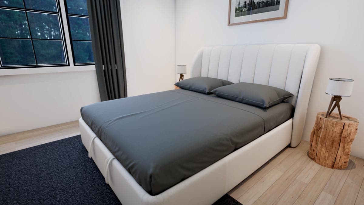 A modern bedroom with a large white bed, gray bedding, and a decorative headboard. A wood stump bedside table holds a lamp.