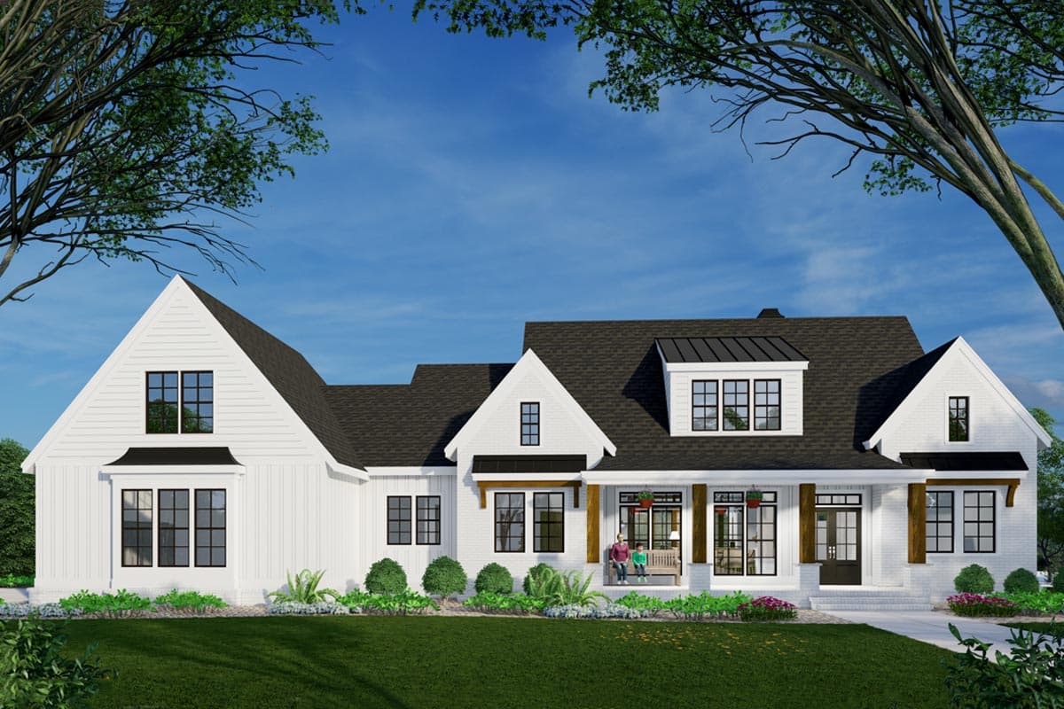 A modern white farmhouse with a black roof, a welcoming porch, and landscaping. Two people sit on the porch swing, enjoying the outdoors.