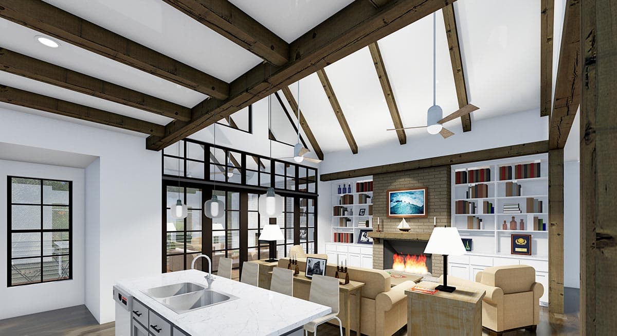 Spacious interior with vaulted ceiling, exposed wooden beams, and a fireplace. A kitchen island is in the foreground, with a living area beyond.