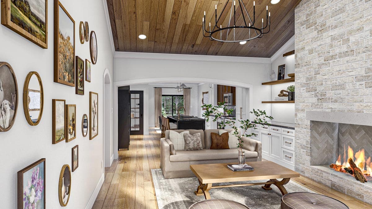 Interior view of a living area with a fireplace, vaulted wood ceiling, and open view to kitchen and dining.