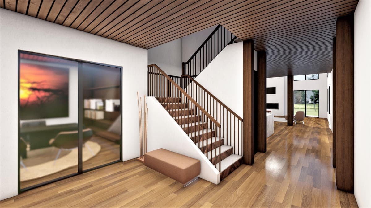 Interior view of a modern home entrance with a floating staircase, wood slat ceiling, and large glass doors.