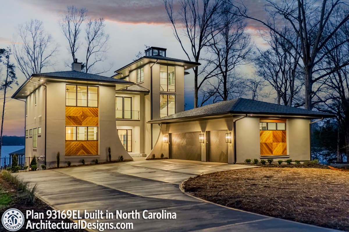 Modern house plan exterior with multiple stories, large windows, decorative wood paneling, and a three-car garage.