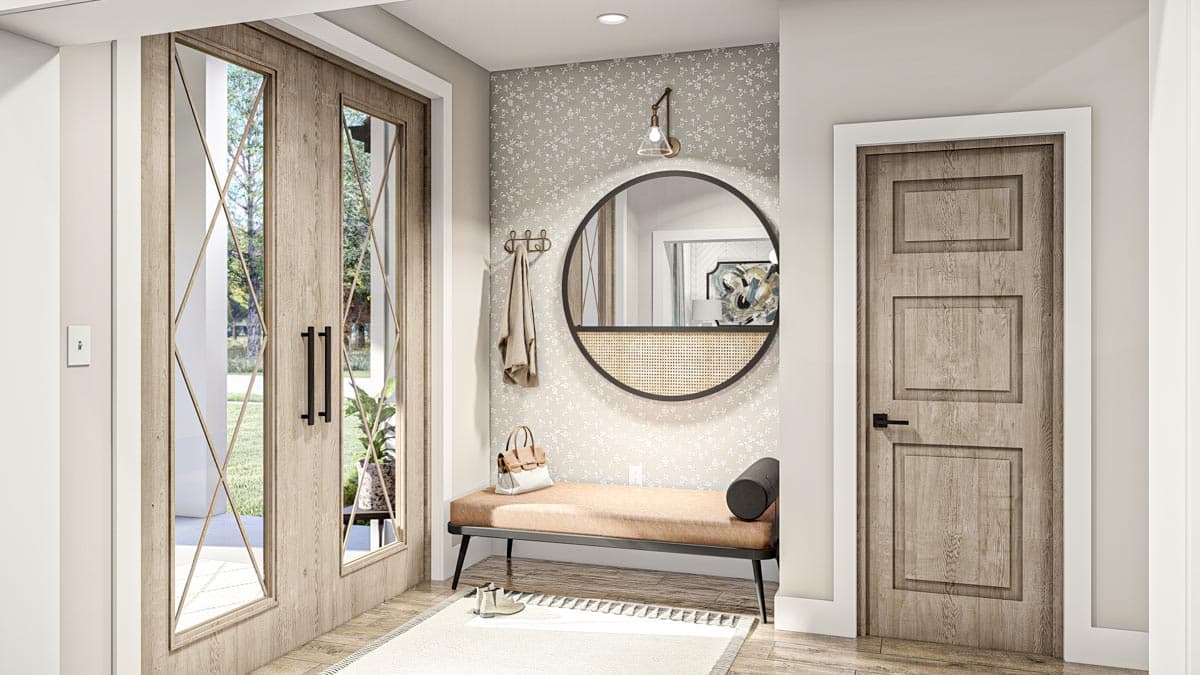 Interior view of entryway with double doors featuring diamond panes, a bench, coat rack, and cane-paneled round mirror.