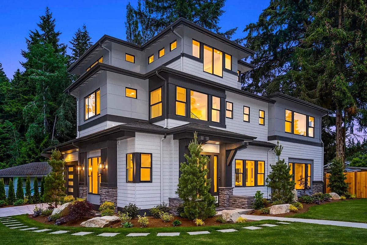 Modern house plan exterior with multiple stories, layered rooflines, large windows, and stone and siding facade.