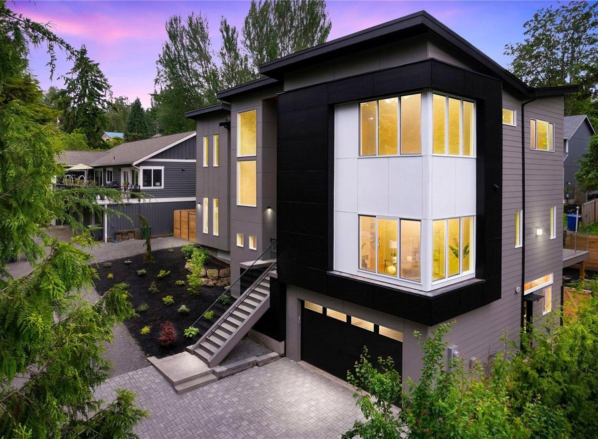 House plan exterior with modern design, two stories, flat roof, and an attached garage. Features include multi-pane windows and a covered entrance.