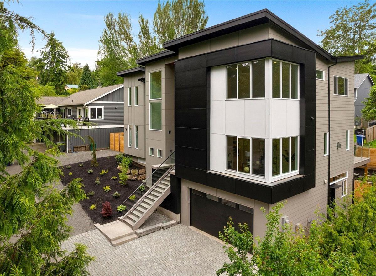 Modern house plan exterior with three stories, a front-facing garage, and stacked window elements.