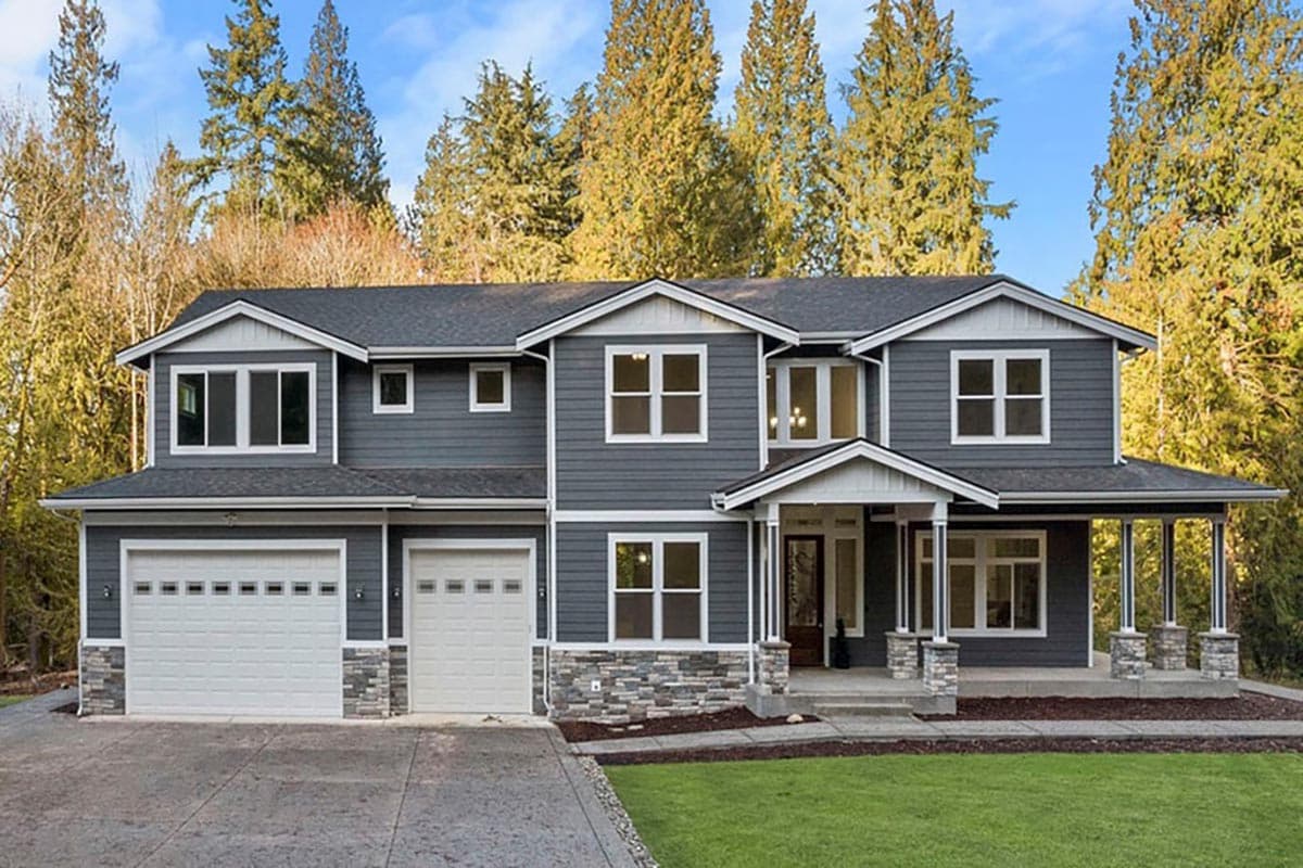 House plan exterior featuring a two-story design with a front porch, gabled roof, and attached garage. Stone accents are present on the facade.