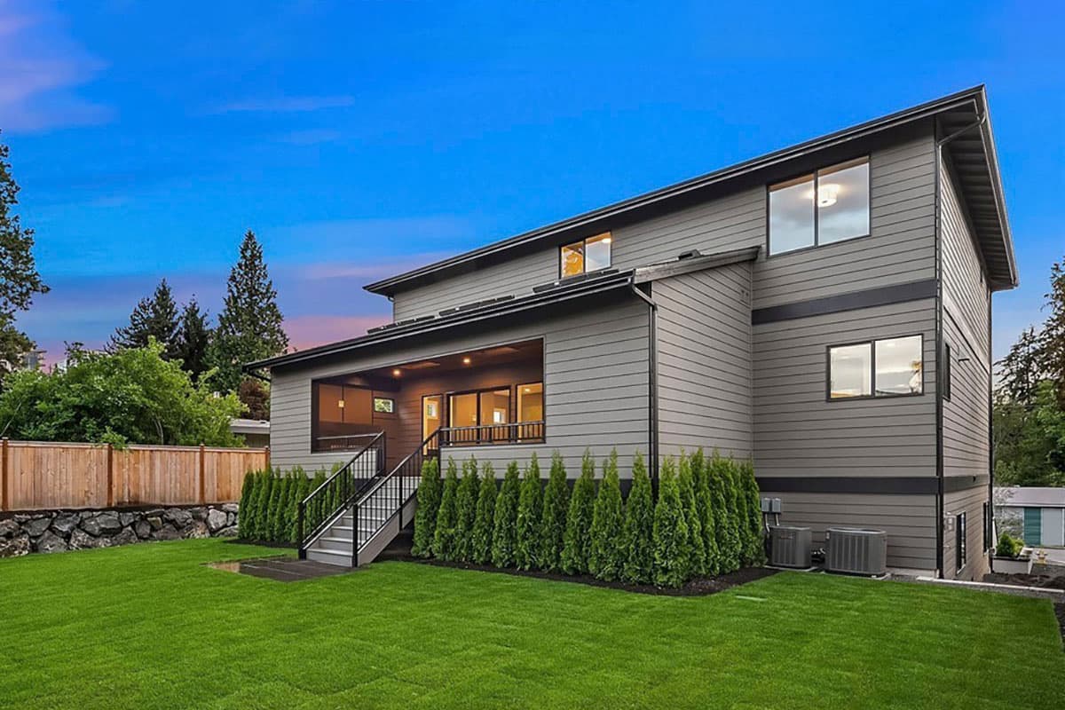 Modern house plan exterior, two stories, with a covered rear porch, horizontal siding, and large windows.