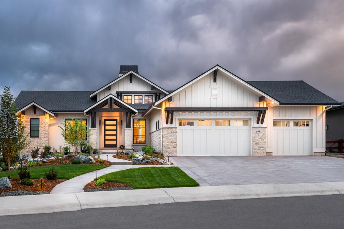 House plan exterior. Modern farmhouse style with a two-car garage, multiple gables, and a covered entry with dark wood accents.