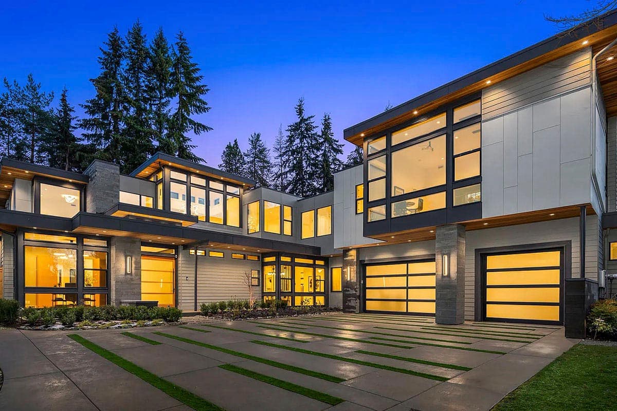 House plan exterior. Modern style with flat rooflines, large windows, and a two-car garage. Features include wood accents and multiple levels.