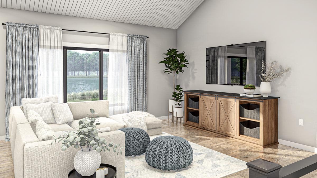 Modern living room with vaulted ceiling, sectional sofa, entertainment console, and large window overlooking a lake.