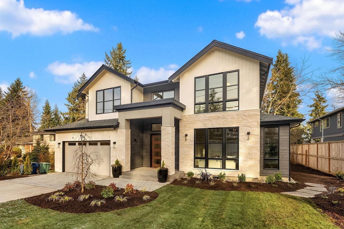 Modern house plan exterior with stone and wood siding, prominent gables, and large black-framed windows. Two stories.