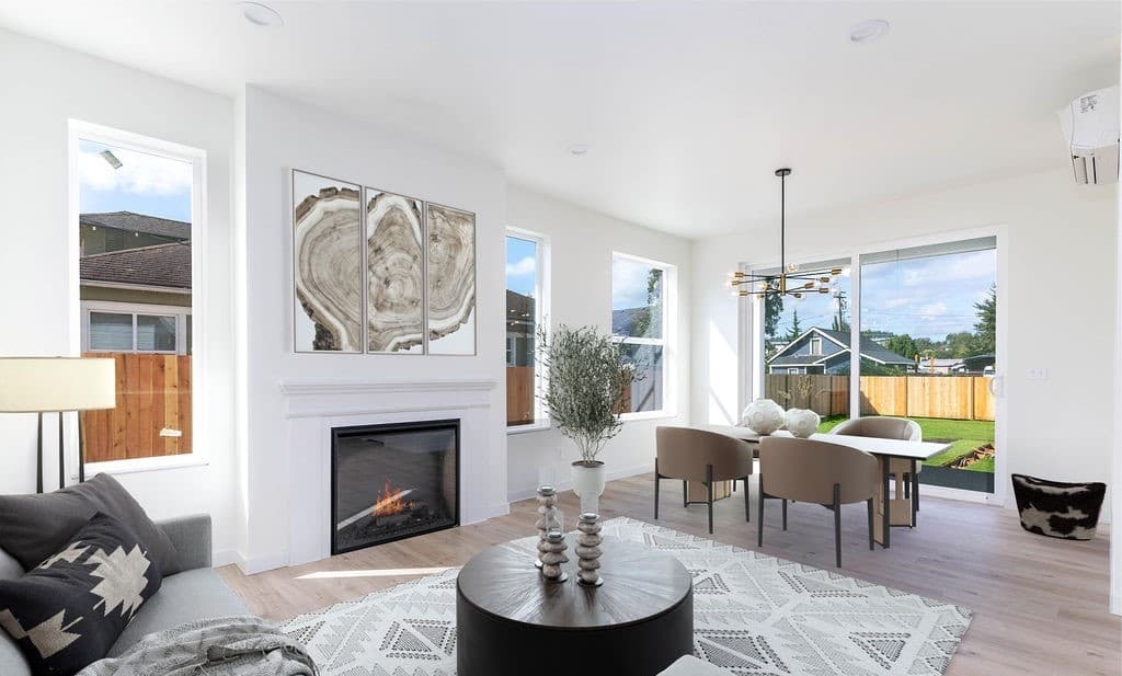 Living and dining area with fireplace, large windows, and access to backyard.