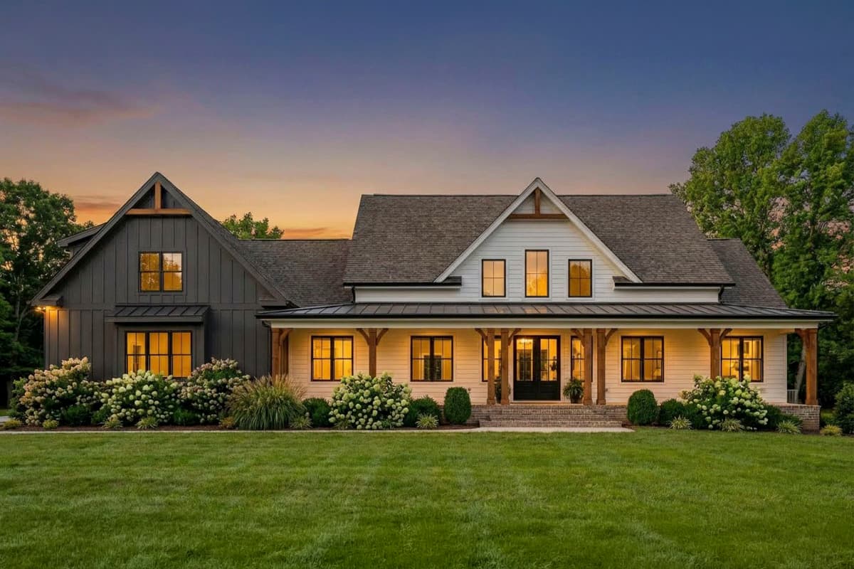 Modern Farmhouse house plan exterior with a wraparound porch, dark gabled section, and white siding.