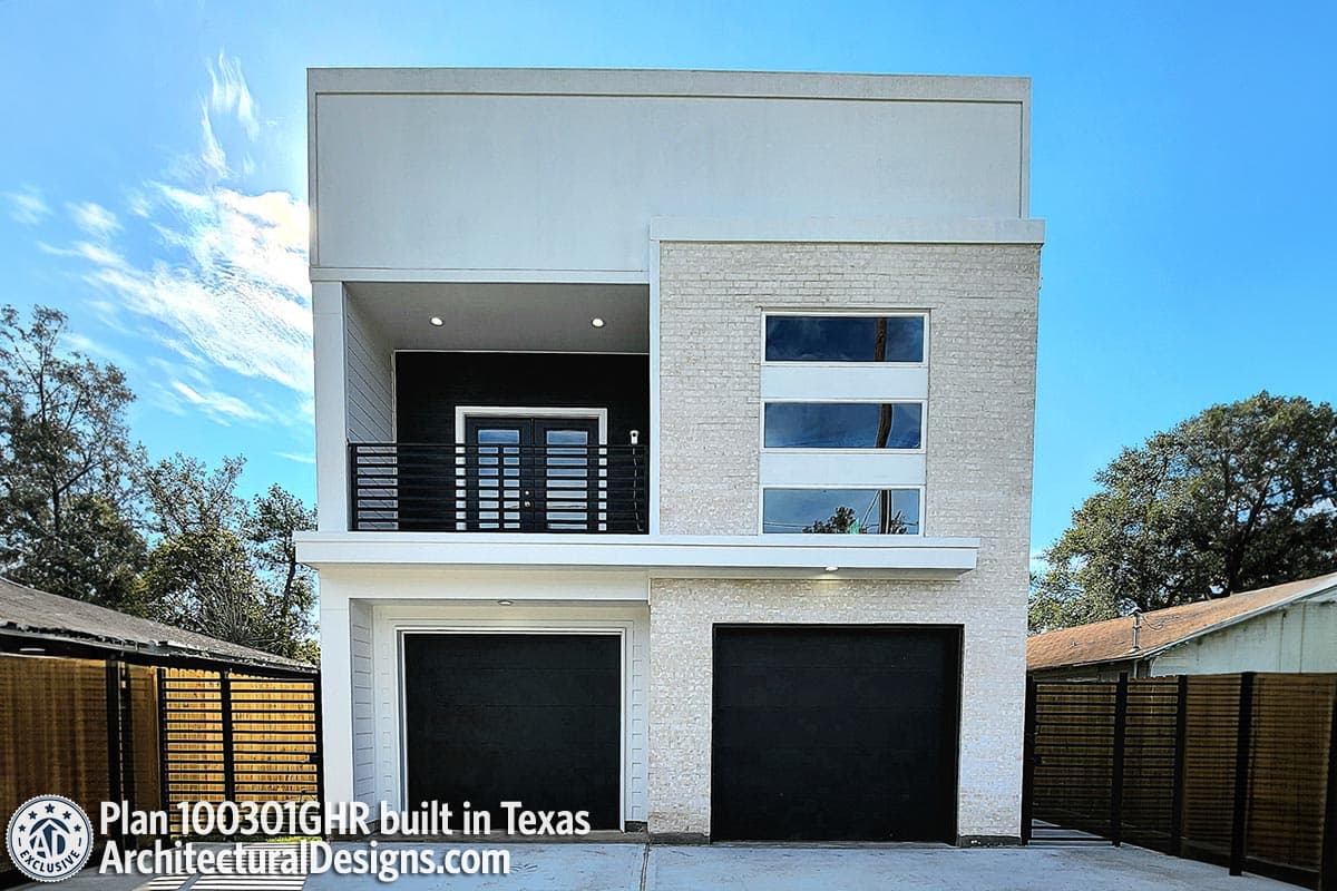 Modern house plan exterior with two-car garage, second-story balcony with black railing, and stacked horizontal windows.